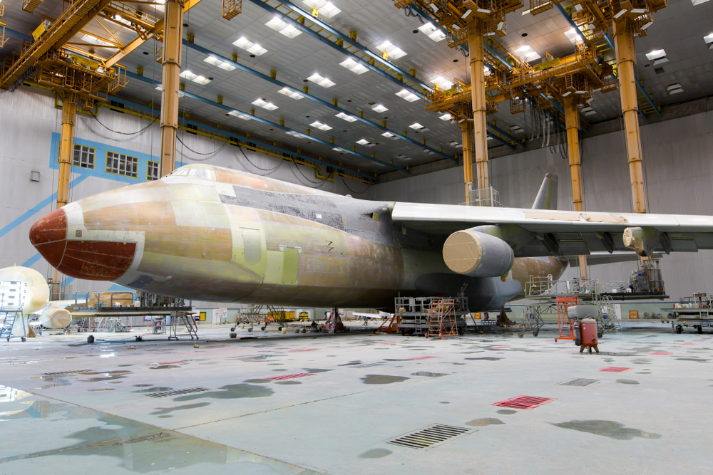 A airplane is shown in a hanger covered with masking material. The plane is being prepared to be painted.