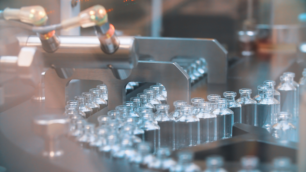 Rows of small bottles on a conveyor belt in a production environment