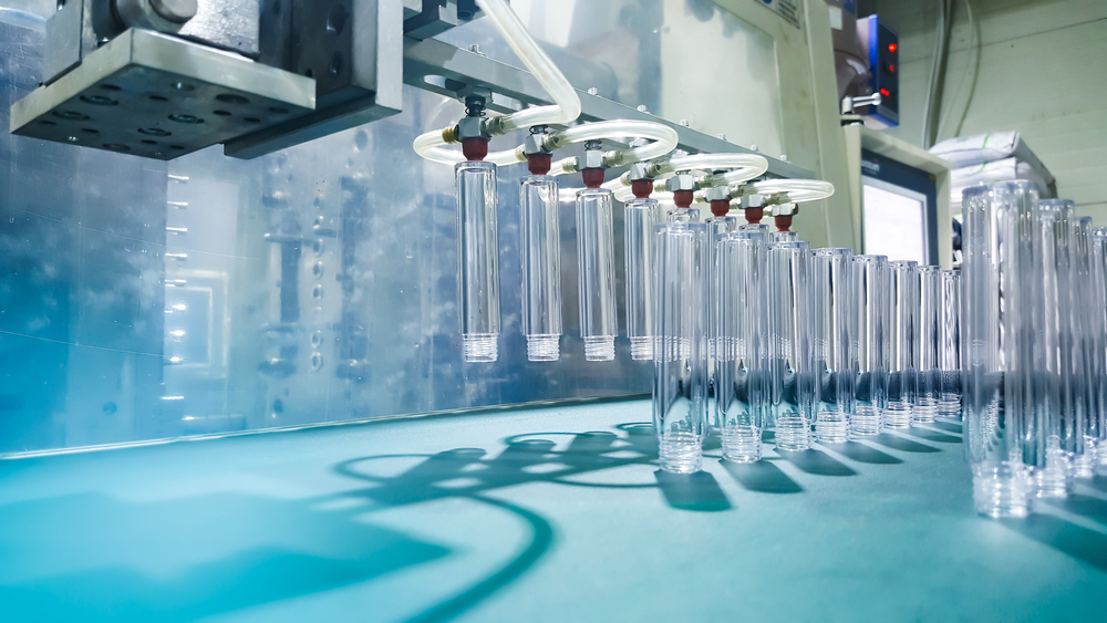 Glass bottles are handled by robotics in a pharmaceutical production application.