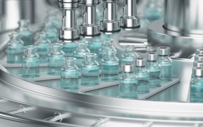 Pharmaceutical robotics handle small glass bottles containing liquid in a high-volume production environment.