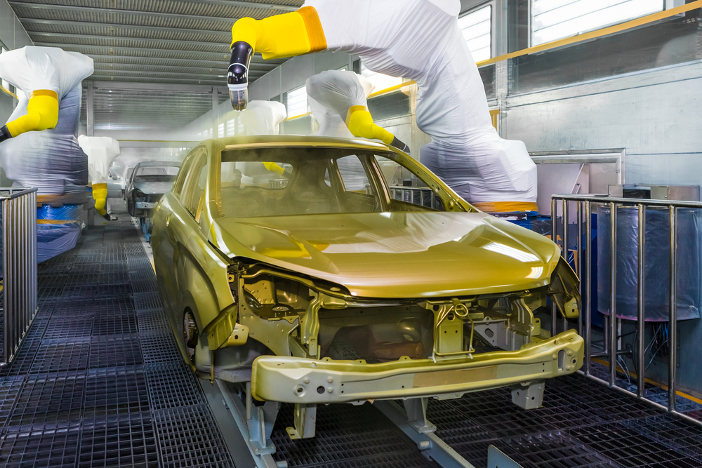 Industrial paint robot applying coating on automobile body