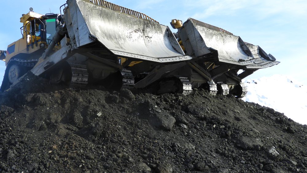two bulldozers side by side on a hill